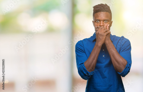 Young african american man over isolated background shocked covering mouth with hands for mistake. Secret concept.