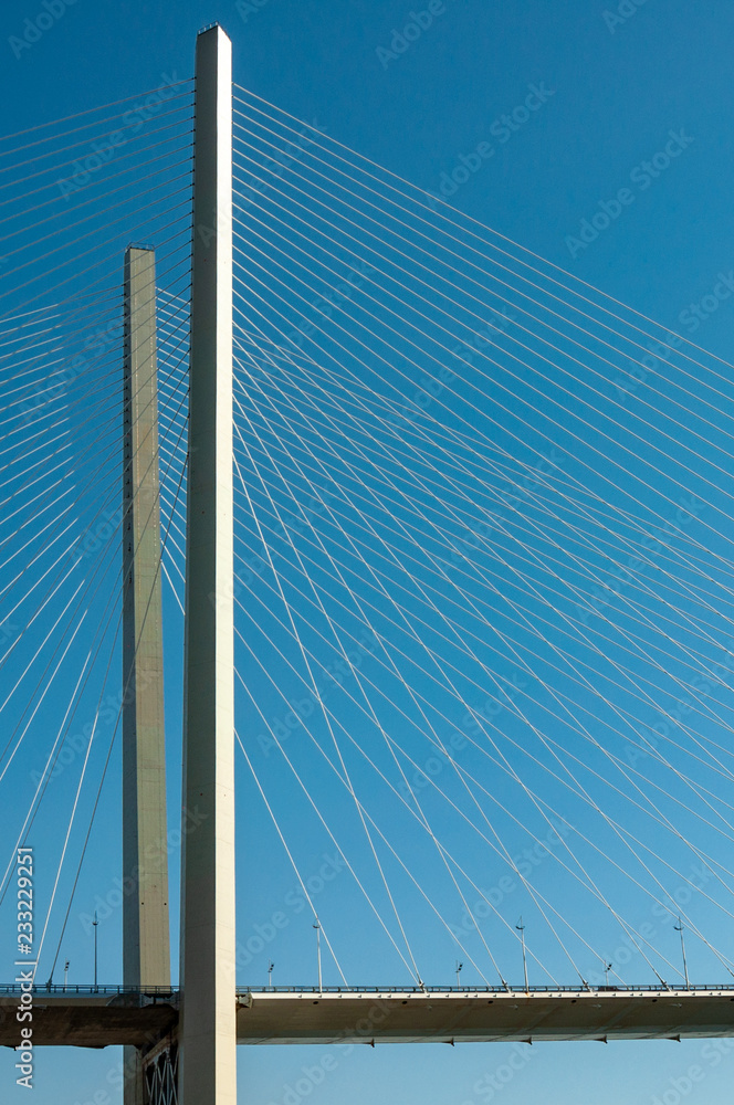 Obraz premium Supports suspension bridge with a web of ropes against the blue sky