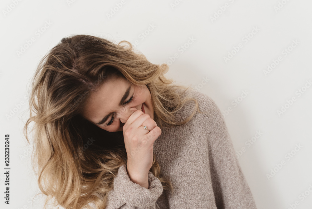 A young woman against a white wall