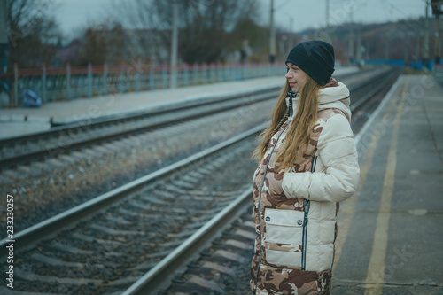 The girl on the railway track in cold weather. Nice girl on a railway road in an autumn day photo