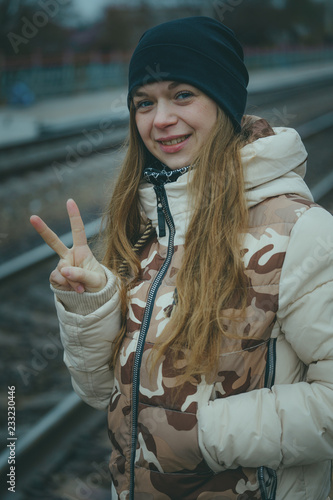 The girl on the railway track in cold weather. Nice girl on a railway road in an autumn day photo