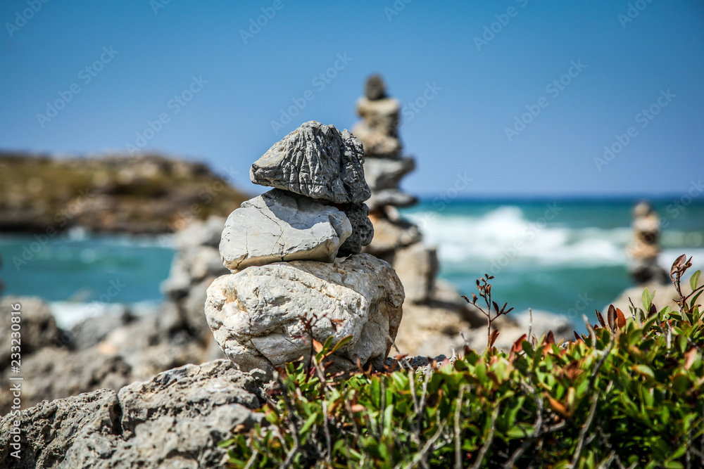 Pyramid of stones on the sea and sky background Pyramid of stones on the sea and sky background
