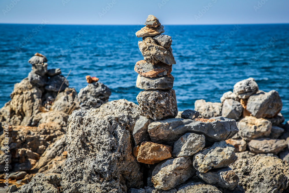 Pyramid of stones on the sea and sky background Pyramid of stones on the sea and sky background