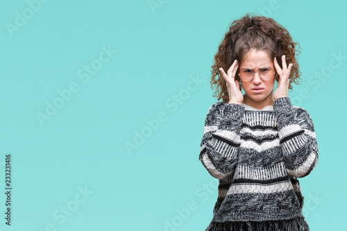 Beautiful brunette curly hair young girl wearing glasses over isolated background with hand on head for pain in head because stress. Suffering migraine.