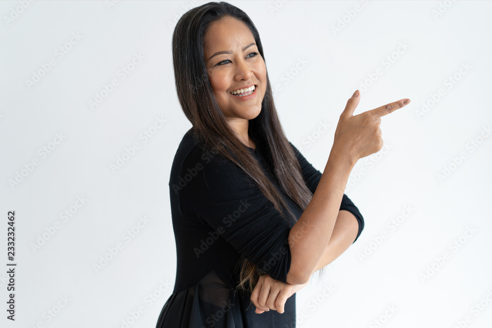 Smiling attractive middle-aged woman pointing aside. Lady looking away and recommending something. Advertisement concept. Isolated view on white background. Smiling attractive middle-aged woman pointing aside. Lady looking away and recommending something. Advertisement concept. Isolated view on white background.