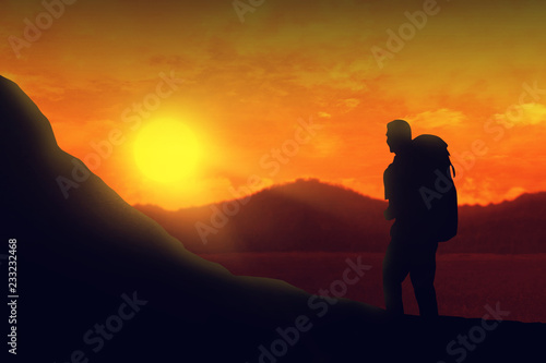 Silhouette of backpacker man hiking the mountain at sunset