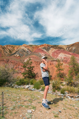 Teen boy in valley of Mars landscapes in the Altai Mountains, Kyzyl Chin, Siberia, Russia