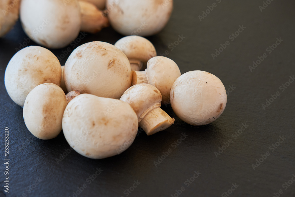 Fototapeta premium Champignon mushrooms on a black background