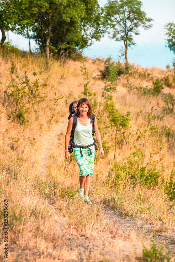 A woman is carrying a backpack with her baby. A woman is carrying a backpack with her baby.