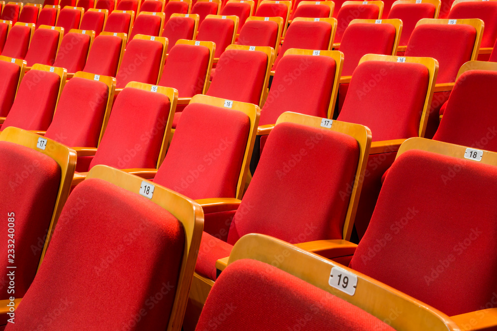 Naklejka premium Red chairs in the auditorium of the theater or concert hall.