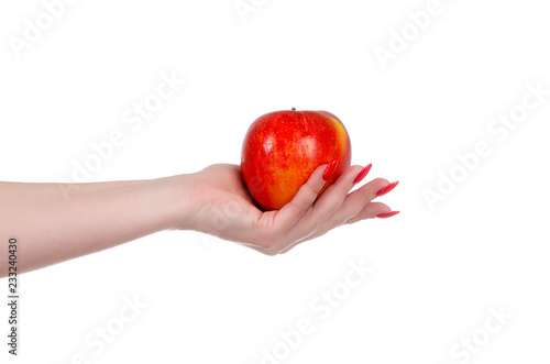 Red apple in the palm of the hand of a young woman on a white background close-up