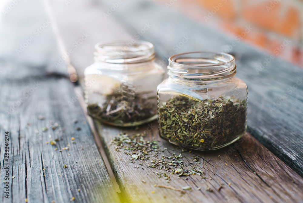 Dried spices in glass jars on wooden table Dried spices in glass jars on wooden table