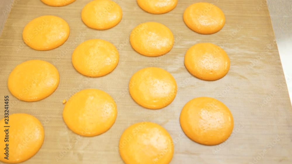 Ready-to-bake macaroons are on parchment for baking. Shadow of sunlight on parchment paper. Preparation for the holiday, preparation for Christmas, New Year, Valentine's Day Ready-to-bake macaroons are on parchment for baking. Shadow of sunlight on parchment paper. Preparation for the holiday, preparation for Christmas, New Year, Valentine's Day