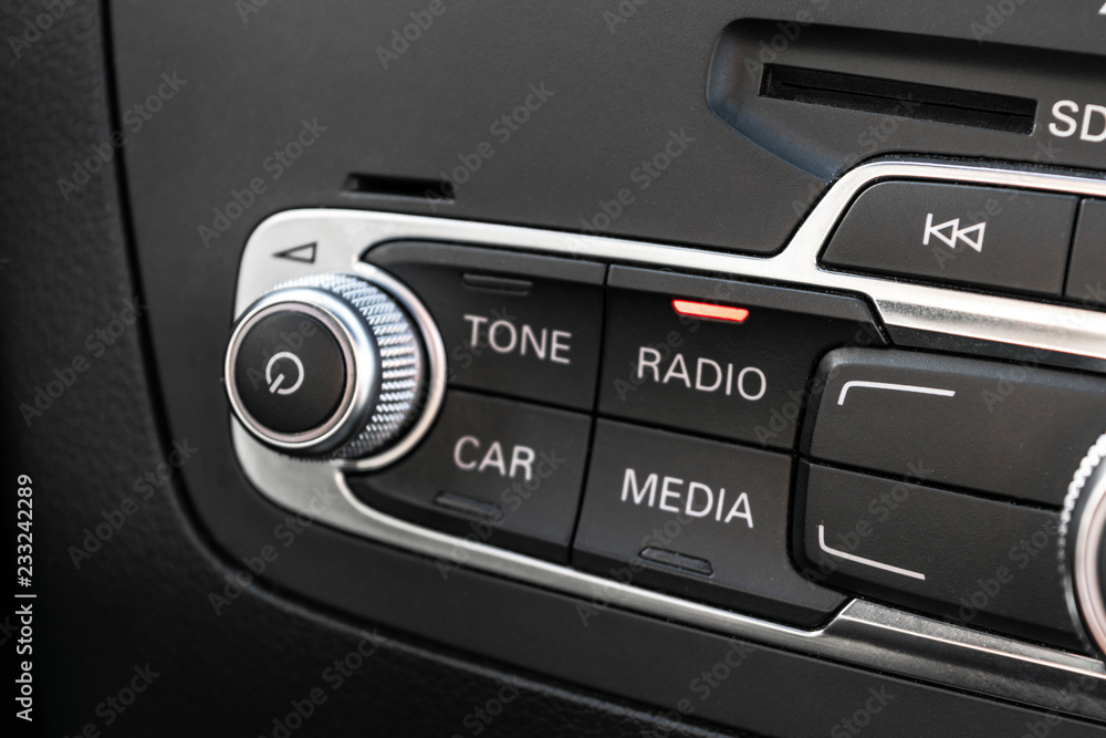 Obraz premium Media and navigation control buttons of a Modern car. Car interior details. Black leather interior of the luxury modern car. Modern car interior. Car detailing
