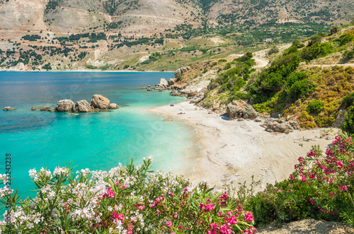 Vouti beach, Kefalonia island, Greece. People relaxing at the beach. The beach is surrounded by flowers.