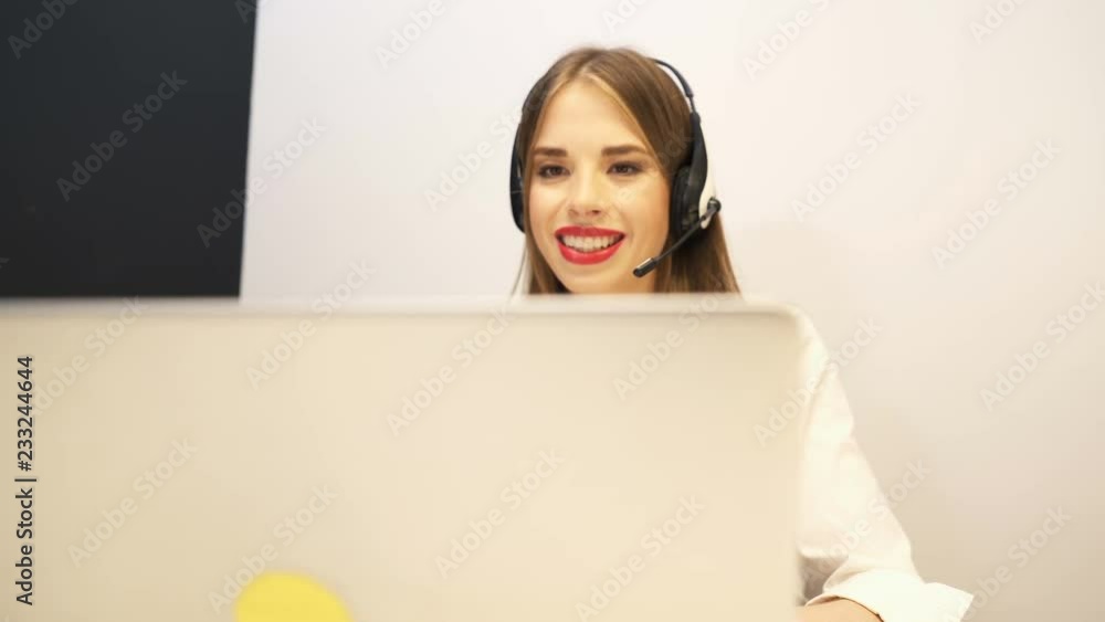 4K.Young woman operator work in customer support service center. Slider  dolly shot, in end look at camera