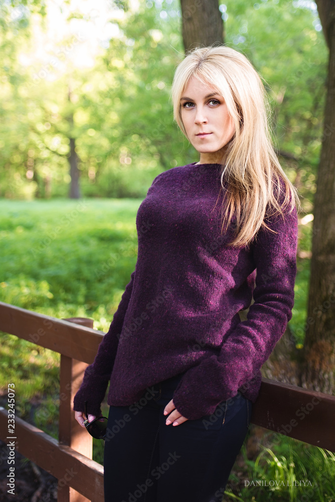 A walk in the Park. A girl with blond hair walks in the Park on a Sunny spring day. Blonde in the sun A walk in the Park. A girl with blond hair walks in the Park on a Sunny spring day. Blonde in the sun