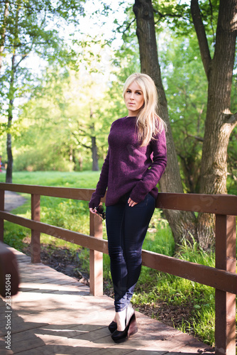 A walk in the Park. A girl with blond hair walks in the Park on a Sunny spring day. Blonde in the sun