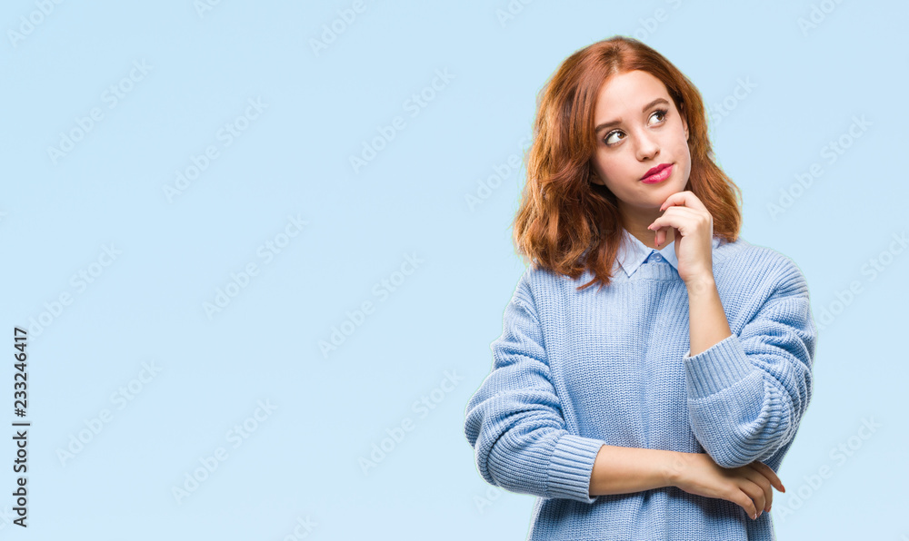 Fototapeta premium Young beautiful woman over isolated background wearing winter sweater with hand on chin thinking about question, pensive expression. Smiling with thoughtful face. Doubt concept.