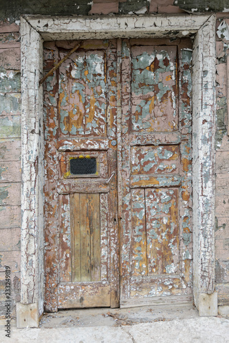 Old wooden weathered door with the old paint flaking