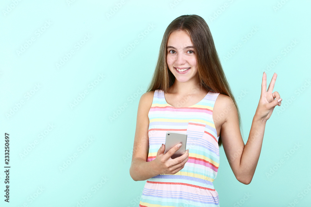 Beautiful girl with smartphone on mint background Beautiful girl with smartphone on mint background