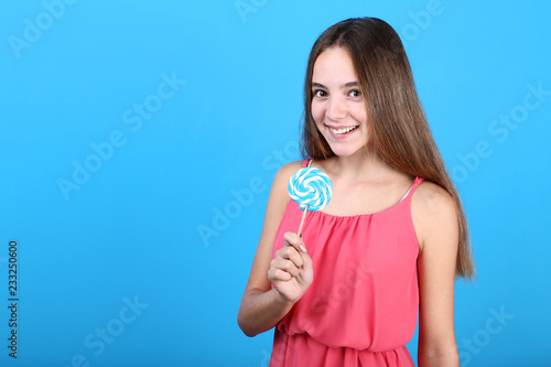 Young girl with lollipop on blue background