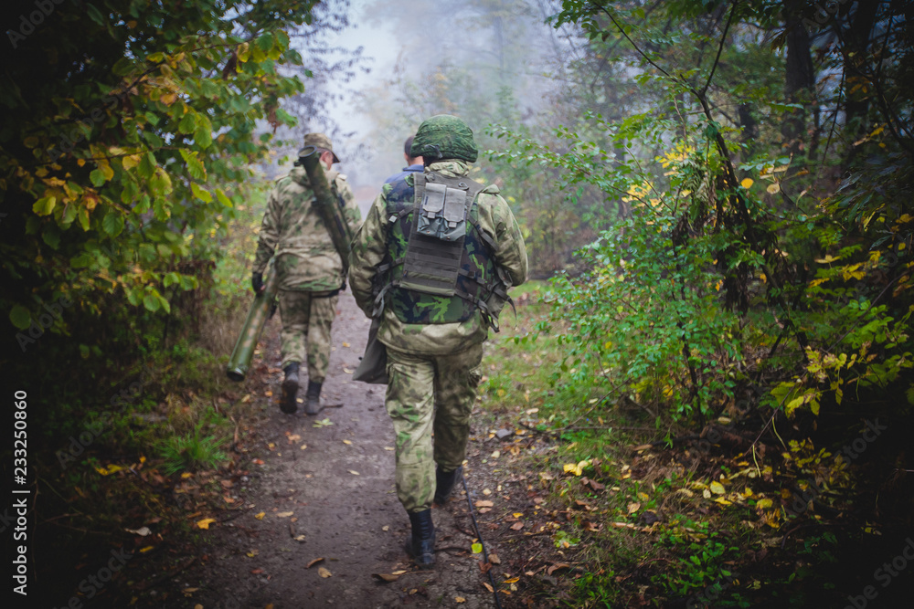 Soldiers with a rocket launcher goes through the woods