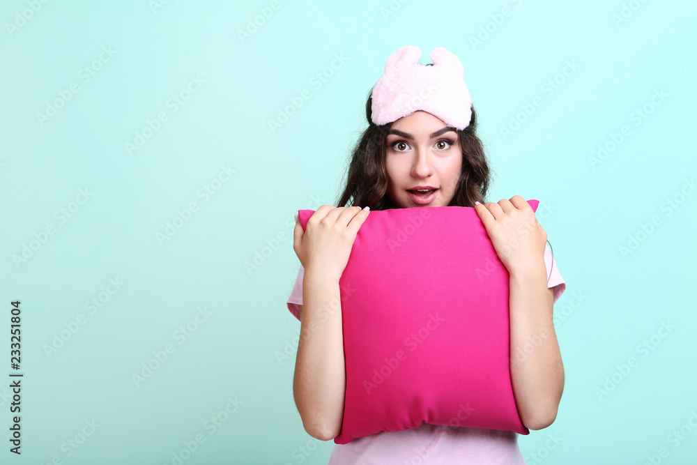 Beautiful girl with sleeping mask and pink pillow on mint background Beautiful girl with sleeping mask and pink pillow on mint background
