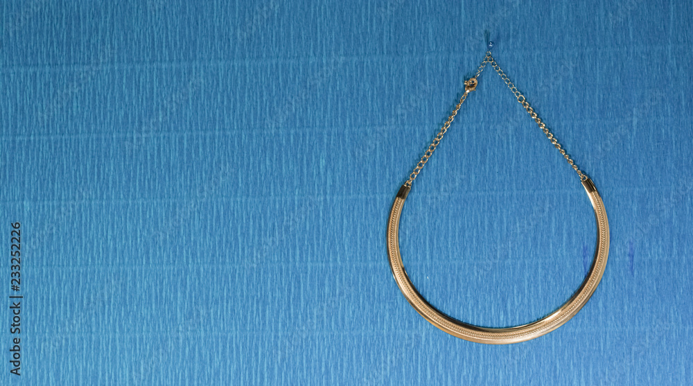 gold chain jewelry on blue background