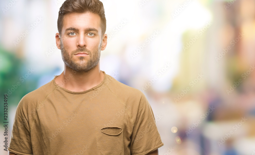 Young handsome man over isolated background with serious expression on face. Simple and natural looking at the camera. Young handsome man over isolated background with serious expression on face. Simple and natural looking at the camera.