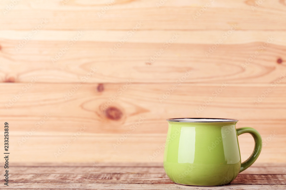 Green mug on brown wooden table Green mug on brown wooden table