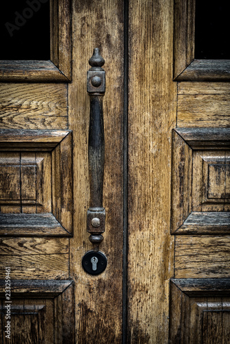 old wooden entrance door with antique door handle.