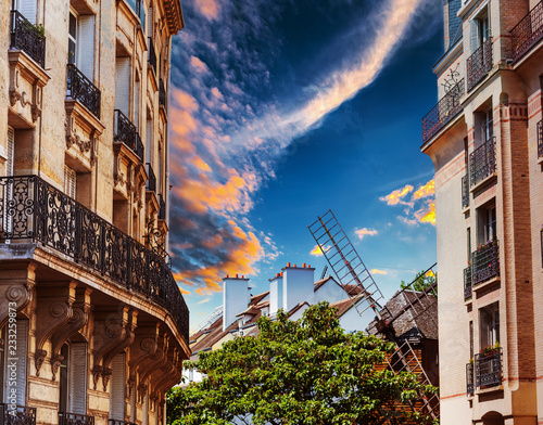 Elegant building and windmill in Montmartre neighborhood at sunset photo