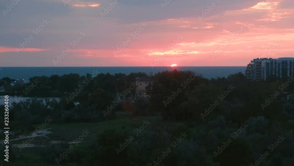 Sun at sunset over the sea in a coastal town. Pink sunset over the sea. Sun at sunset over the sea in a coastal town. Pink sunset over the sea.