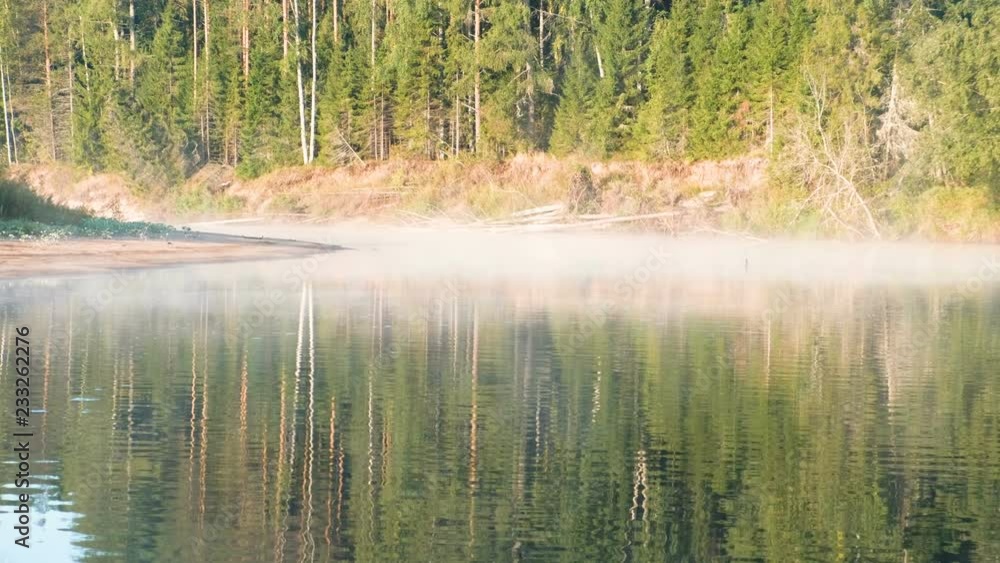 Mist over the river. Autumn forest is reflected in the water on the riverbank. Mist over the river. Autumn forest is reflected in the water on the riverbank.
