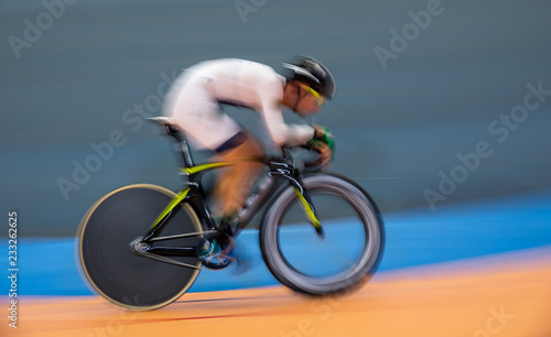 Profile blurred motion of cyclist competing indoor