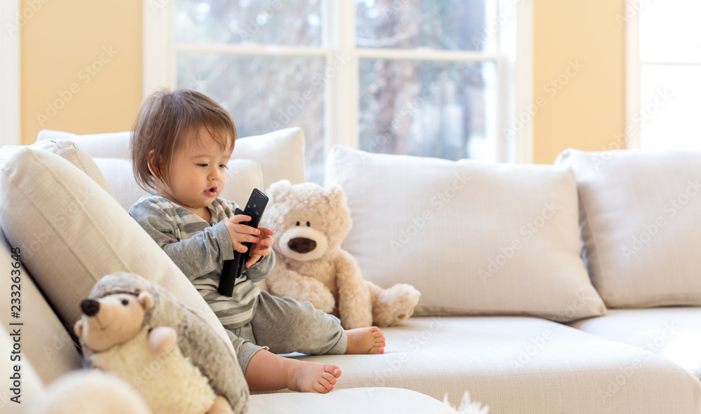 Little toddler boy with a TV remote control Little toddler boy with a TV remote control