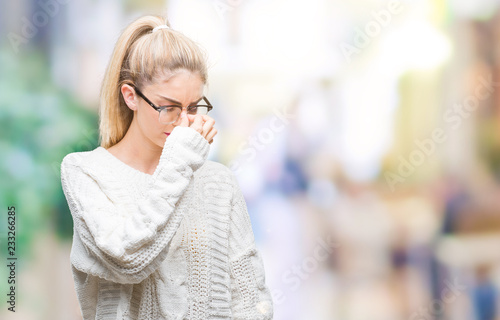Young beautiful blonde woman wearing glasses over isolated background tired rubbing nose and eyes feeling fatigue and headache. Stress and frustration concept.