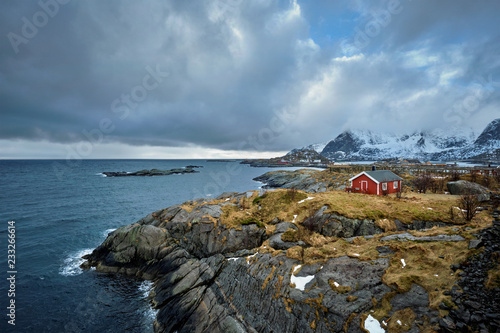 Clif with traditional red rorbu house on Lofoten Islands, Norway