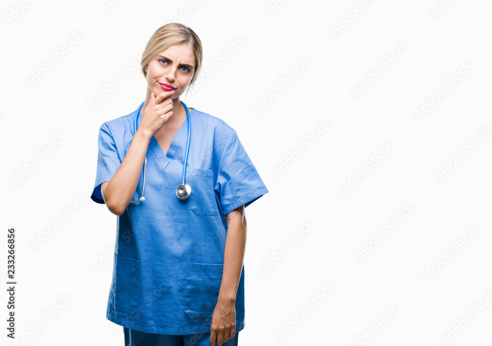 Young beautiful blonde doctor surgeon nurse woman over isolated background looking confident at the camera with smile with crossed arms and hand raised on chin. Thinking positive. Young beautiful blonde doctor surgeon nurse woman over isolated background looking confident at the camera with smile with crossed arms and hand raised on chin. Thinking positive.
