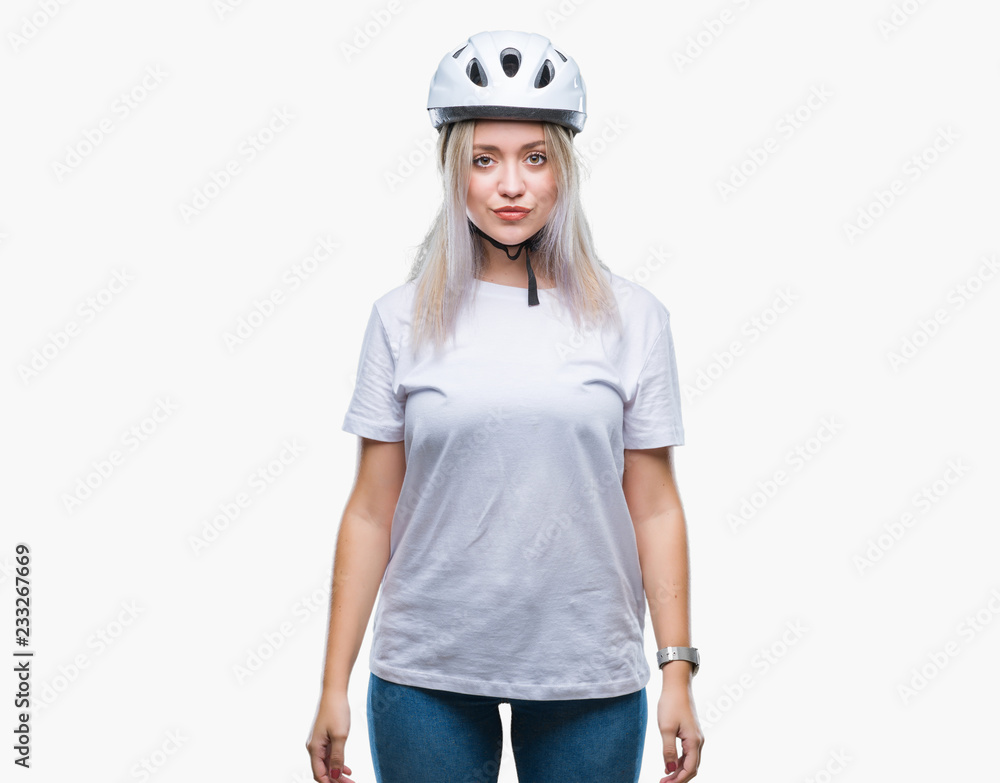 Young blonde woman wearing cyclist security helmet over isolated background with serious expression on face. Simple and natural looking at the camera. Young blonde woman wearing cyclist security helmet over isolated background with serious expression on face. Simple and natural looking at the camera.