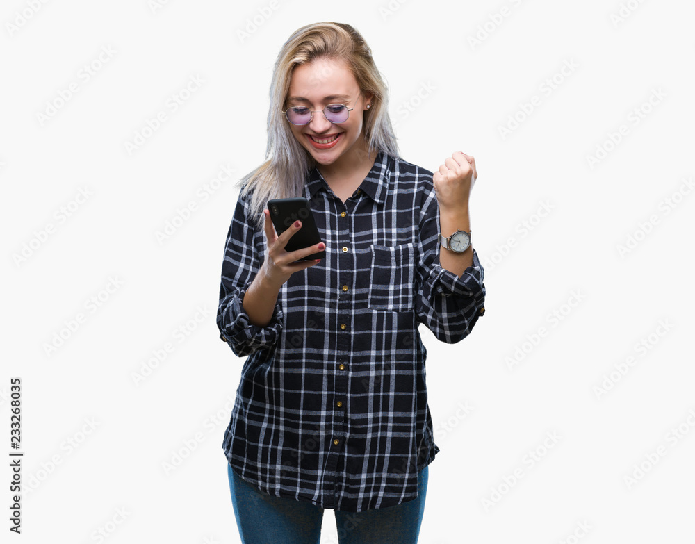 Young blonde woman texting sending message using smartphone over isolated background screaming proud and celebrating victory and success very excited, cheering emotion Young blonde woman texting sending message using smartphone over isolated background screaming proud and celebrating victory and success very excited, cheering emotion