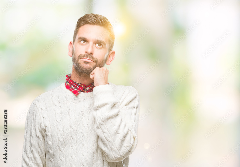 Young handsome man wearing winter sweater over isolated background with hand on chin thinking about question, pensive expression. Smiling with thoughtful face. Doubt concept. Young handsome man wearing winter sweater over isolated background with hand on chin thinking about question, pensive expression. Smiling with thoughtful face. Doubt concept.