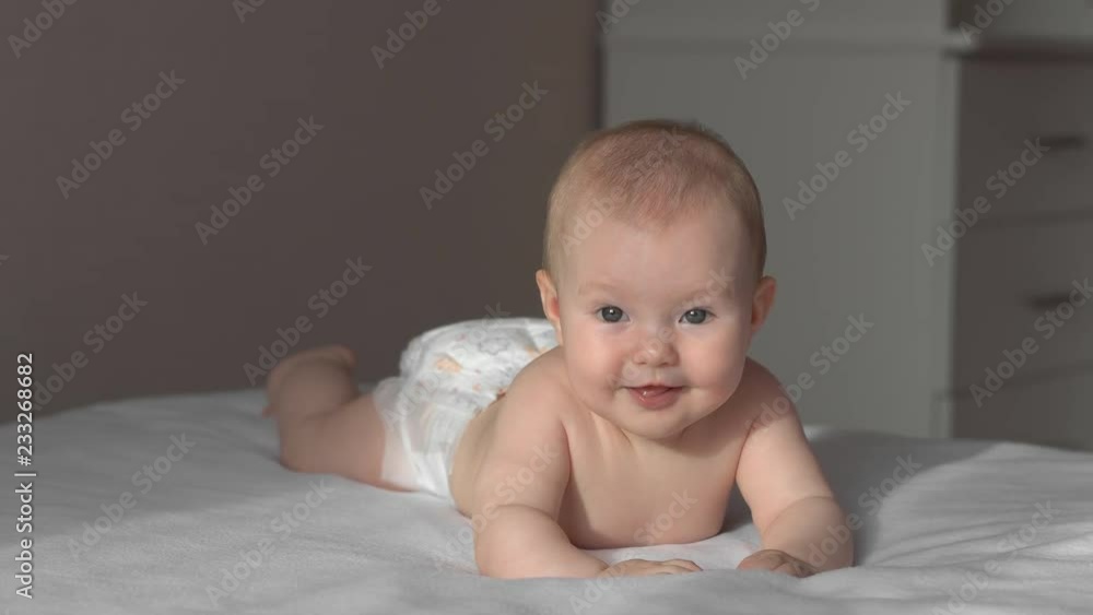 Happy baby girl. The baby is lying on the bed and laughing. 4K Happy baby girl. The baby is lying on the bed and laughing. 4K