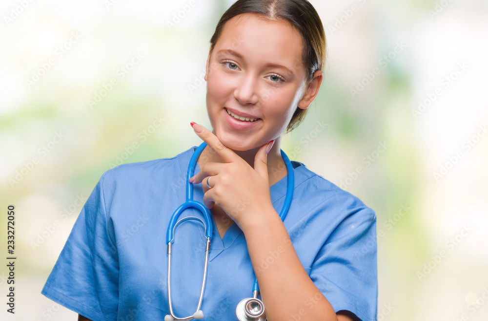 Young caucasian doctor woman wearing medical uniform over isolated background looking confident at the camera with smile with crossed arms and hand raised on chin. Thinking positive.