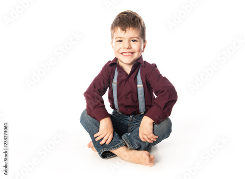 A four year old boy posing over white studio background