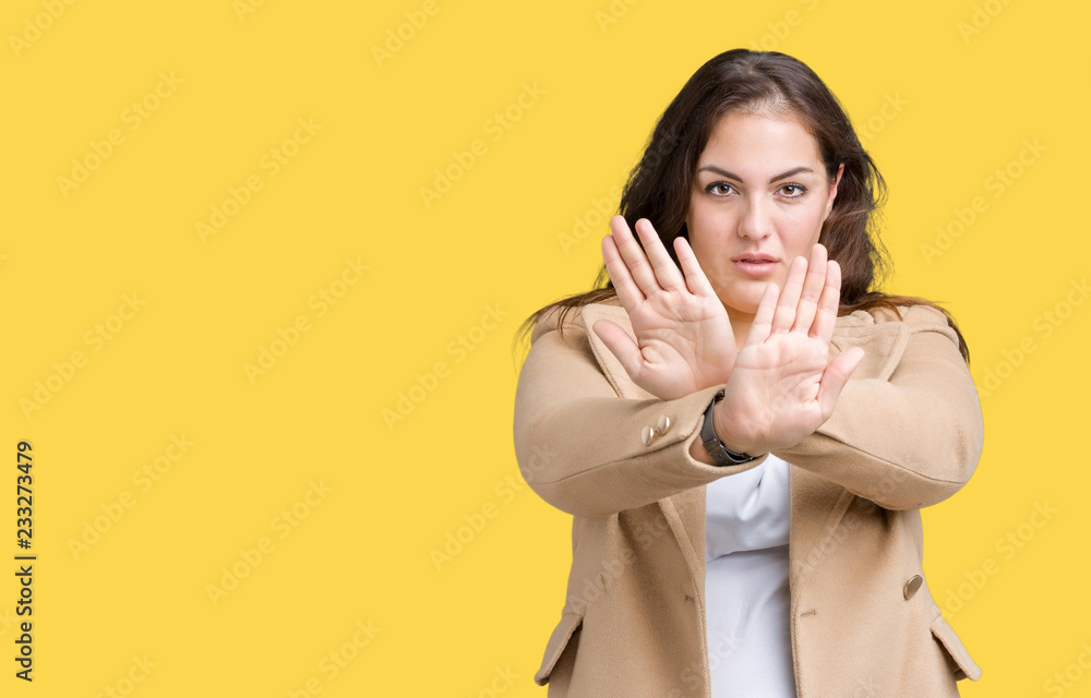 Beautiful plus size young woman wearing winter coat over isolated background Rejection expression crossing arms and palms doing negative sign, angry face Beautiful plus size young woman wearing winter coat over isolated background Rejection expression crossing arms and palms doing negative sign, angry face