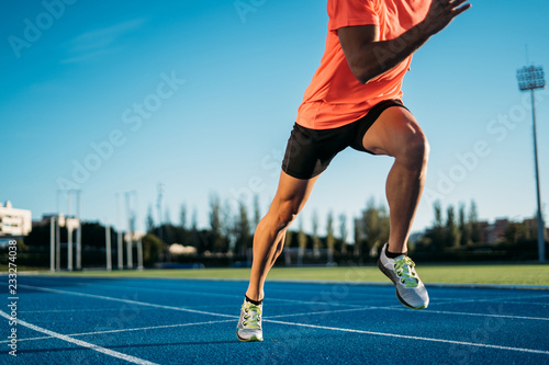Young athlete man starting to run in a start position in a race. Start stride photo