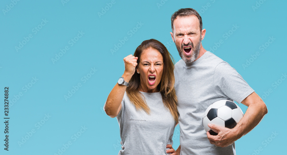Middle age hispanic couple holding football soccer ball over isolated background annoyed and frustrated shouting with anger, crazy and yelling with raised hand, anger concept Middle age hispanic couple holding football soccer ball over isolated background annoyed and frustrated shouting with anger, crazy and yelling with raised hand, anger concept