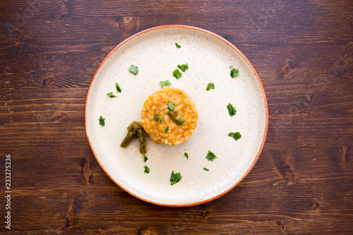 Risotto with asparagus cream on a wooden table seen from above